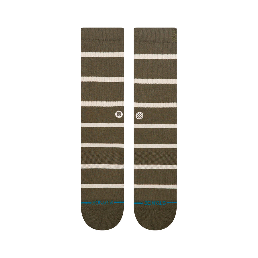 Pair of green stance butter blend crew socks with white stripes on a white background