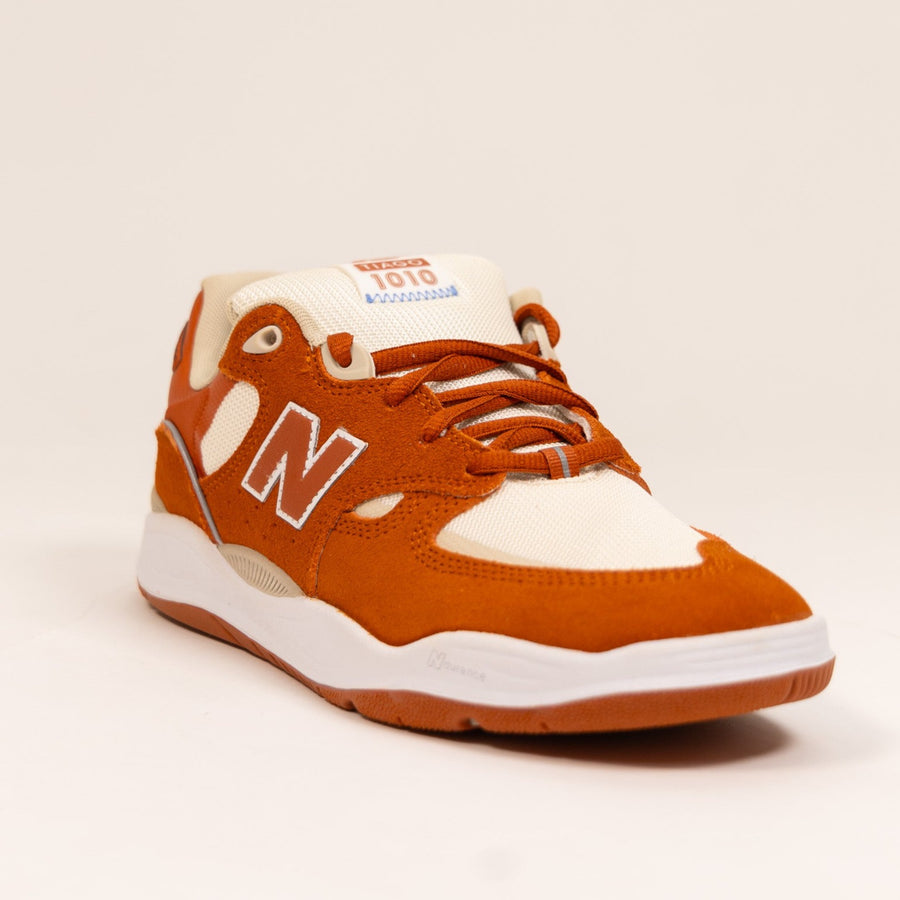 orange and white men's new balance skate shoe with white sole