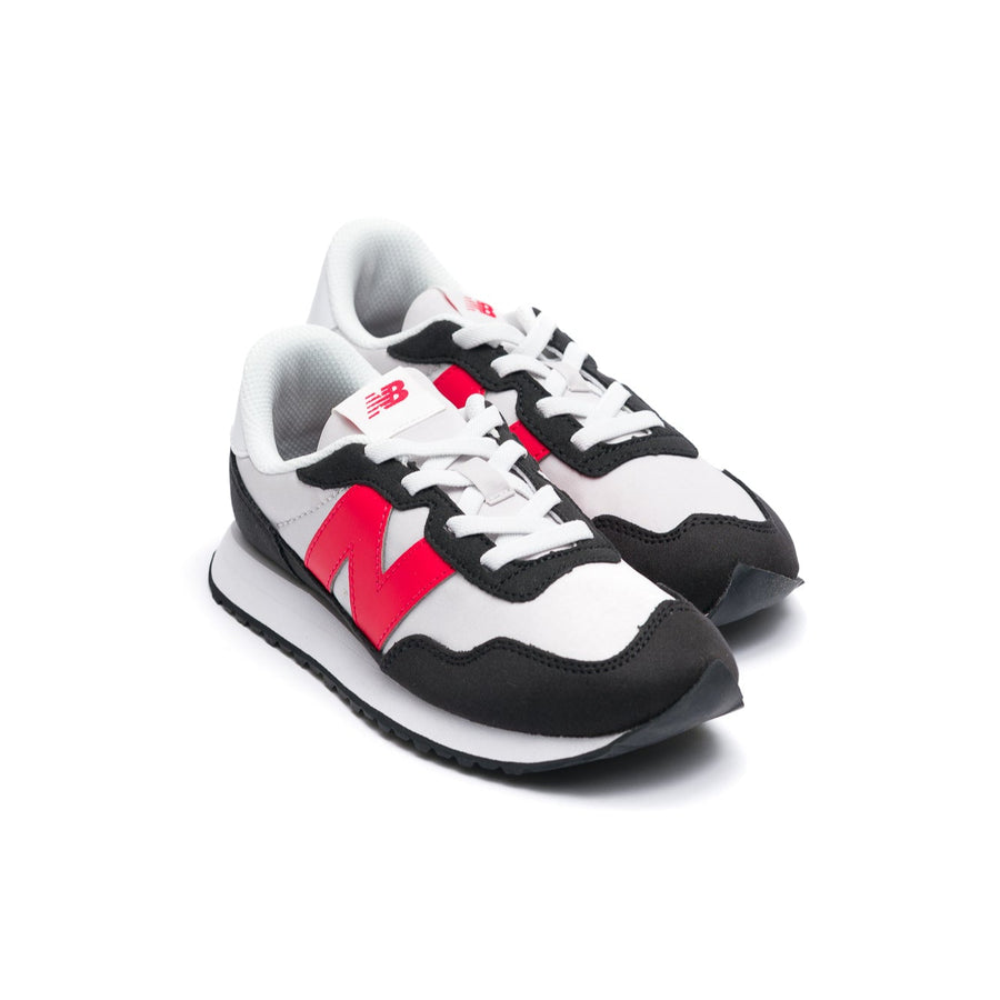 Black and white new balance 237 kids and toddler sneaker with red accents on a white background