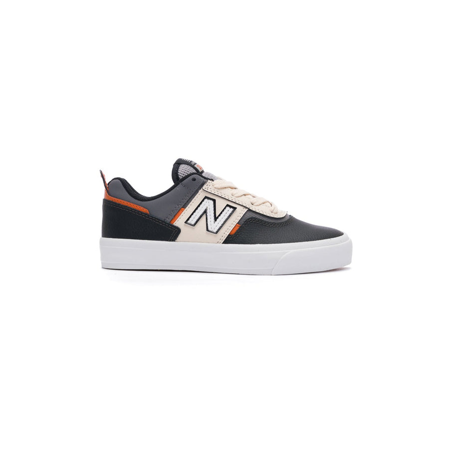 Black and white new balance numeric kids skateboarding sneaker with orange accents on a white background