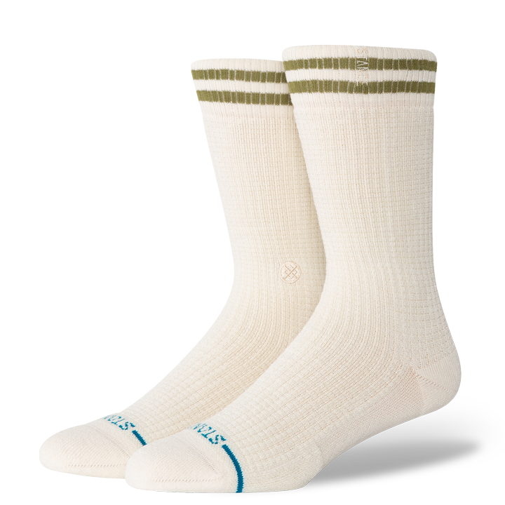 Pair of cream stance women's butterblend crew socks with green stripes on a white background
