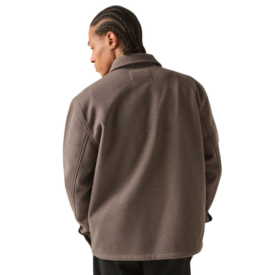 brown grey brixton trademark zip flannel jacket on a man in black pants on a white background