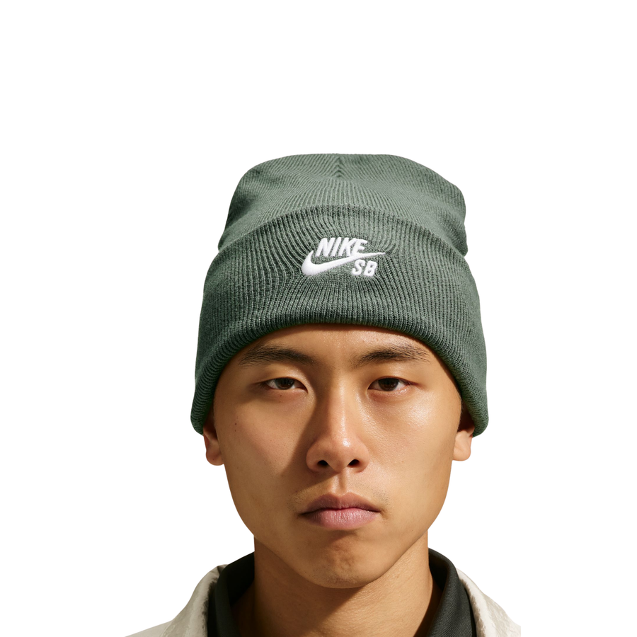 woman wearing a dark green nike sb beanie on a white background