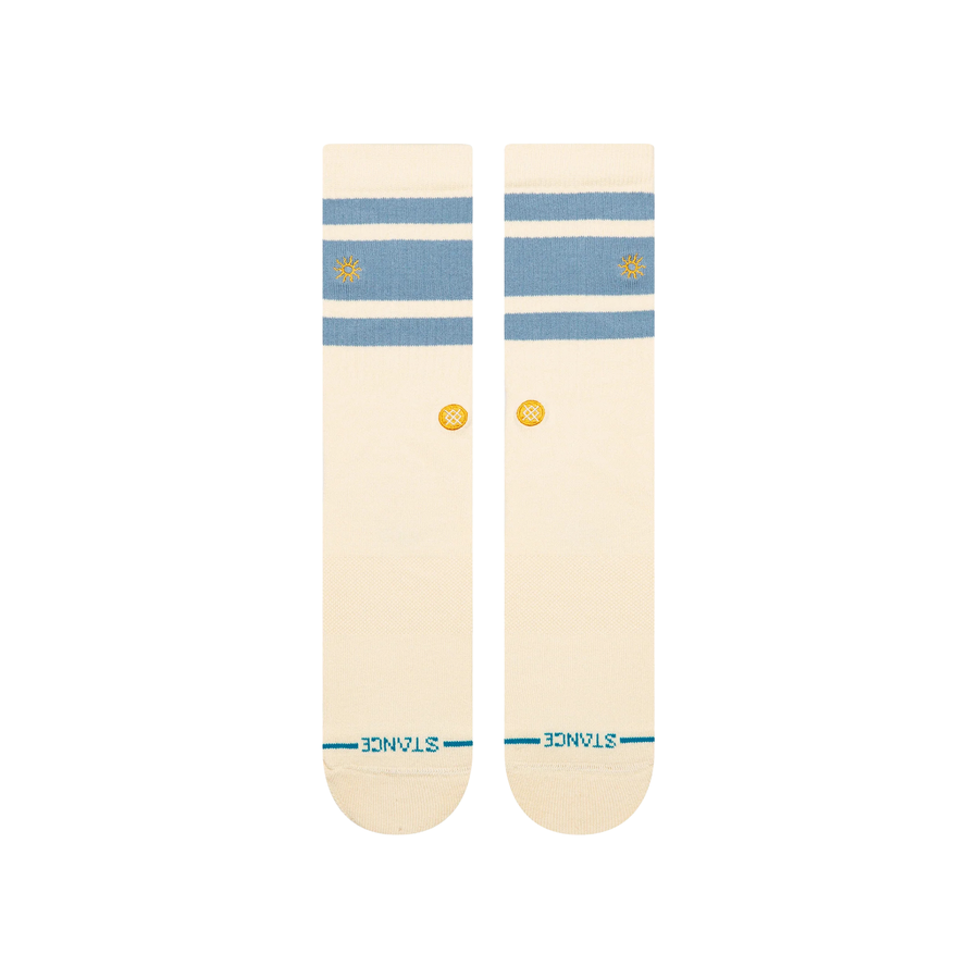 A pair of Stance got sol crew socks in cream with light blue horizontal stripes near the cuff, a small yellow logo on the side, and teal lettering on the toes, shown against a plain white background.
