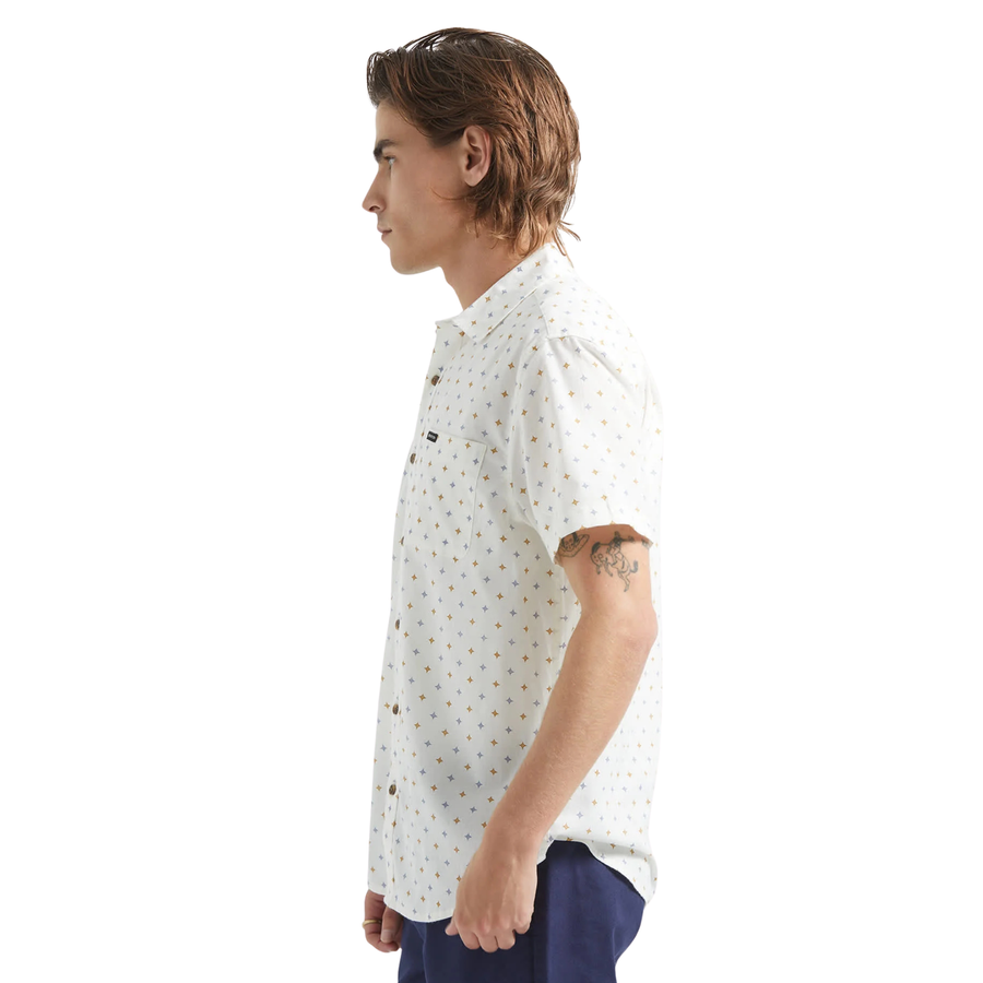 Man wearing a white brixton charter print short-sleeve shirt with a subtle pattern on a white background