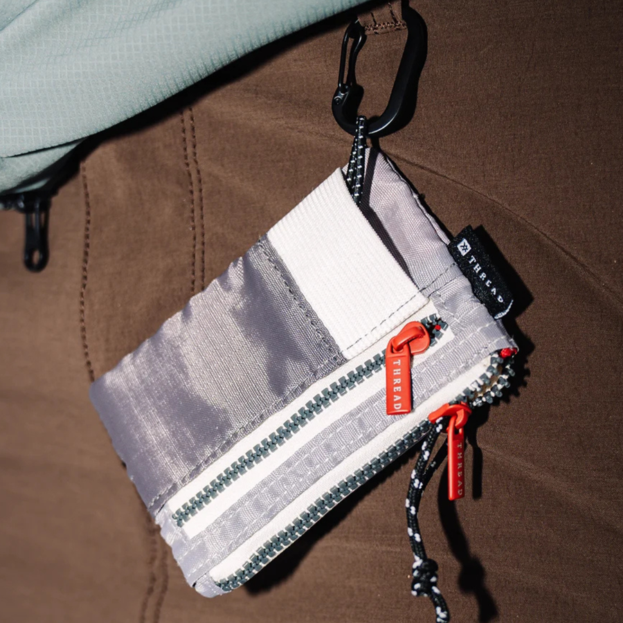 grey and white thread zipper adventure pouch wallet on a white background
