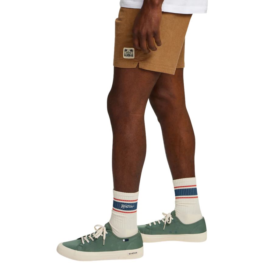 A pair of off-white crew socks with navy and red stripes near the top, featuring the 'howler' logo on the right sock cuff and orange stitching on the toes.