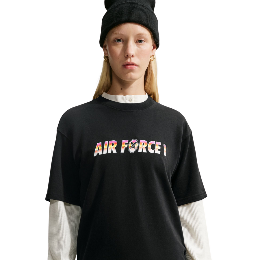 A model wearing a nike sb yuto horigome black t-shirt with 'AIR FORCE 1' printed across the chest in a colorful gradient pattern, styled with gold necklaces and red reflective sunglasses against a plain white background.