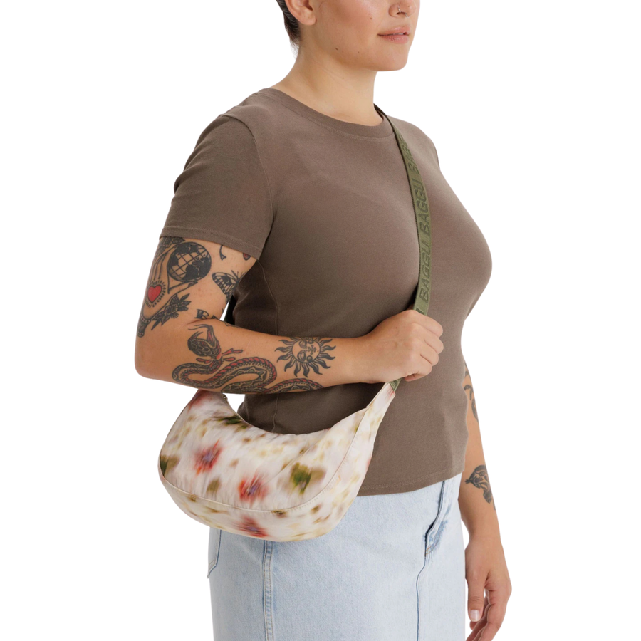 Floral-patterned baggu small crescent nylon handbag with a green strap on a white background