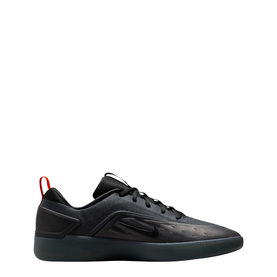 A black Nike nyjah 4 skateboard sneaker with a textured synthetic upper, black laces, a black sole, and a small red pull tab on the heel, shown from a side profile against a white background.