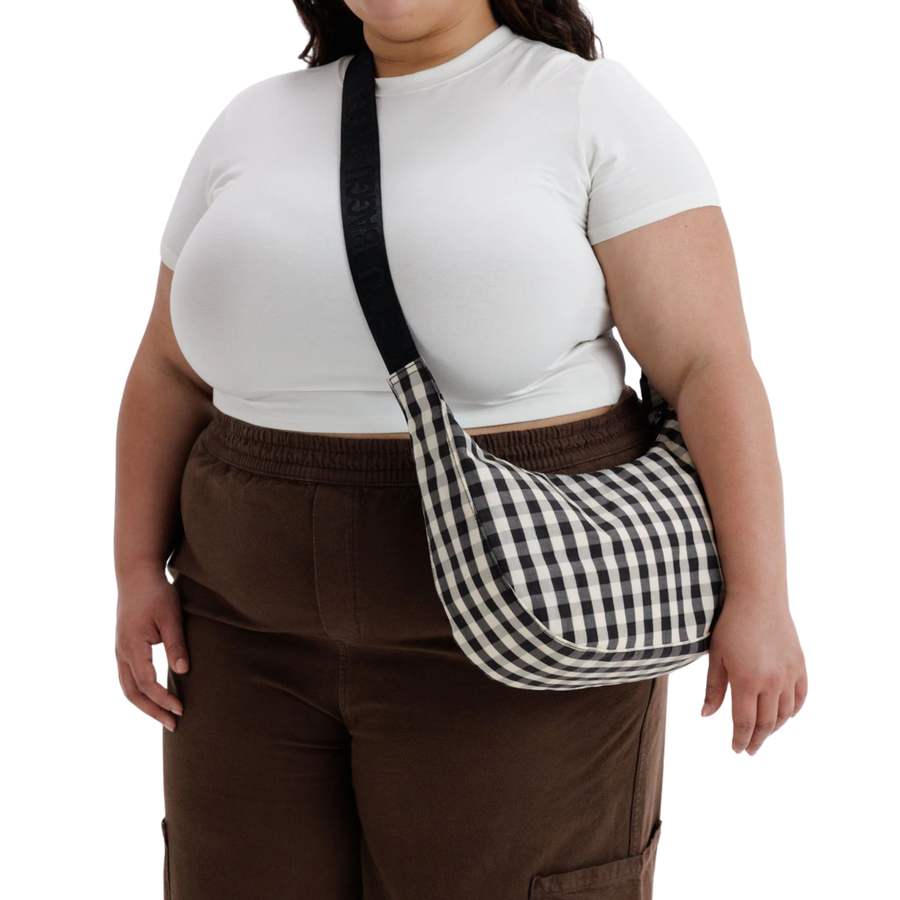 A black and white gingham checkered crescent baggu shoulder bag with a black strap, shown against a plain white background.