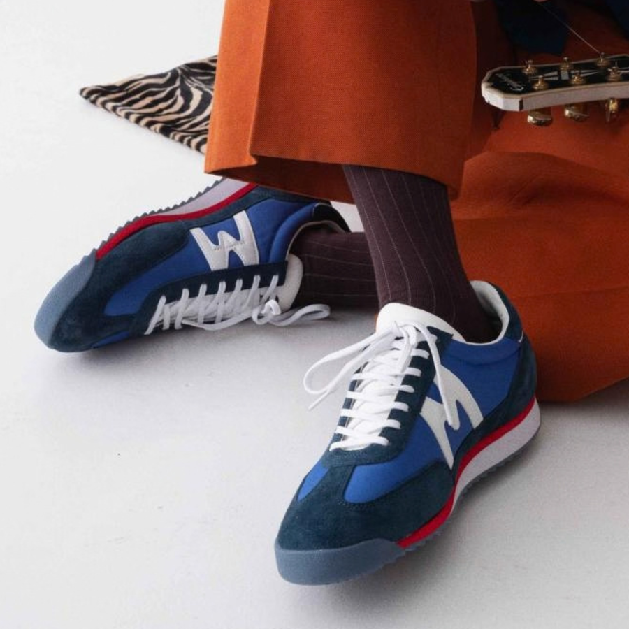 Blue karhu mestari 76 sneaker with red and white sole on a white background