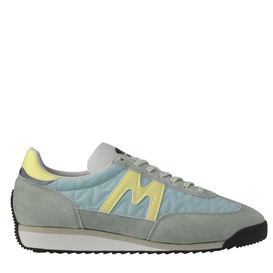 grey and blue karhu mestari Sneaker with a yellow 'M' logo on a white background