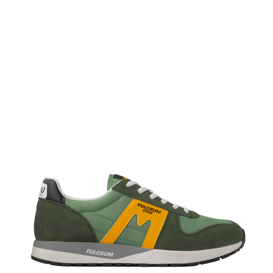 A low-top Karhu Fulcrum Star sneaker, featuring a green mesh and suede upper with a prominent mustard yellow 'M' logo on the side, white laces, and a gray and white midsole.