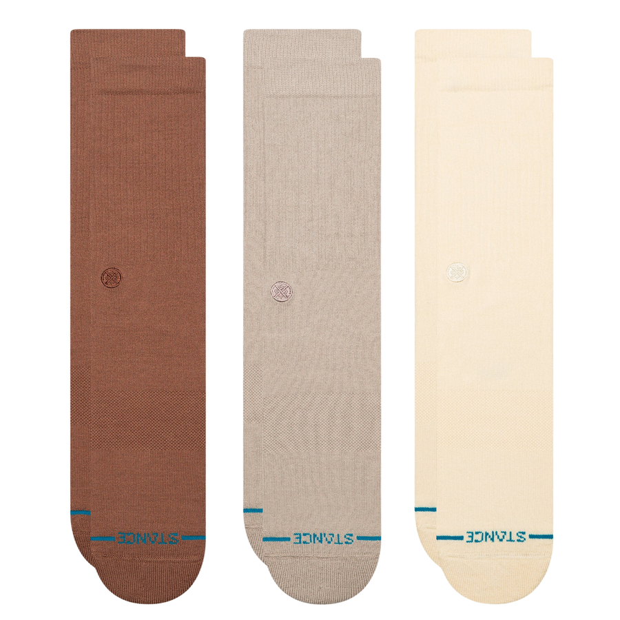 Three pairs of Stance crew socks in brown, beige, and cream, arranged vertically side-by-side on a plain white background.