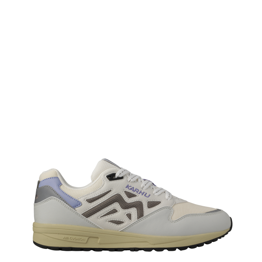 A low-top Legacy 96 sneaker by KARHU in light gray and off-white, featuring a lavender purple heel accent, dark gray side stripes, and a beige midsole.