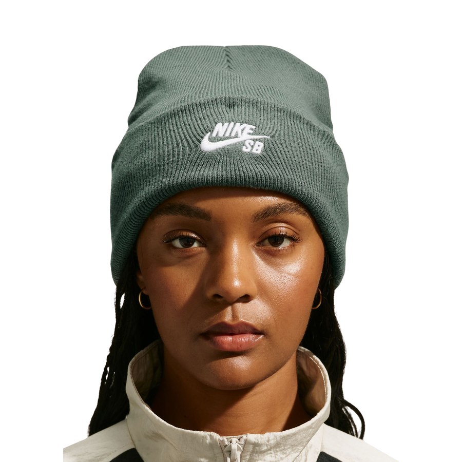 woman wearing a dark green nike sb beanie on a white background
