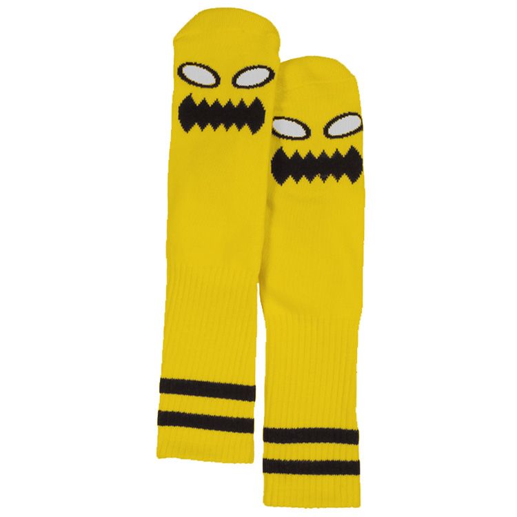 Yellow Crew length toy machine skateboard socks with a monster face design on a white background