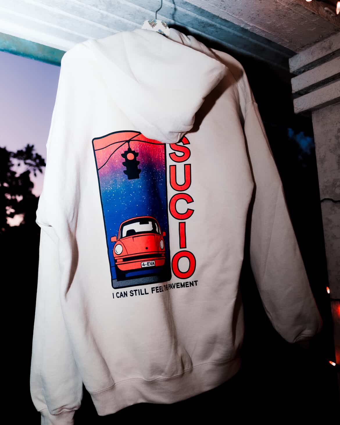 White hoodie with graphic design and text on a dark background