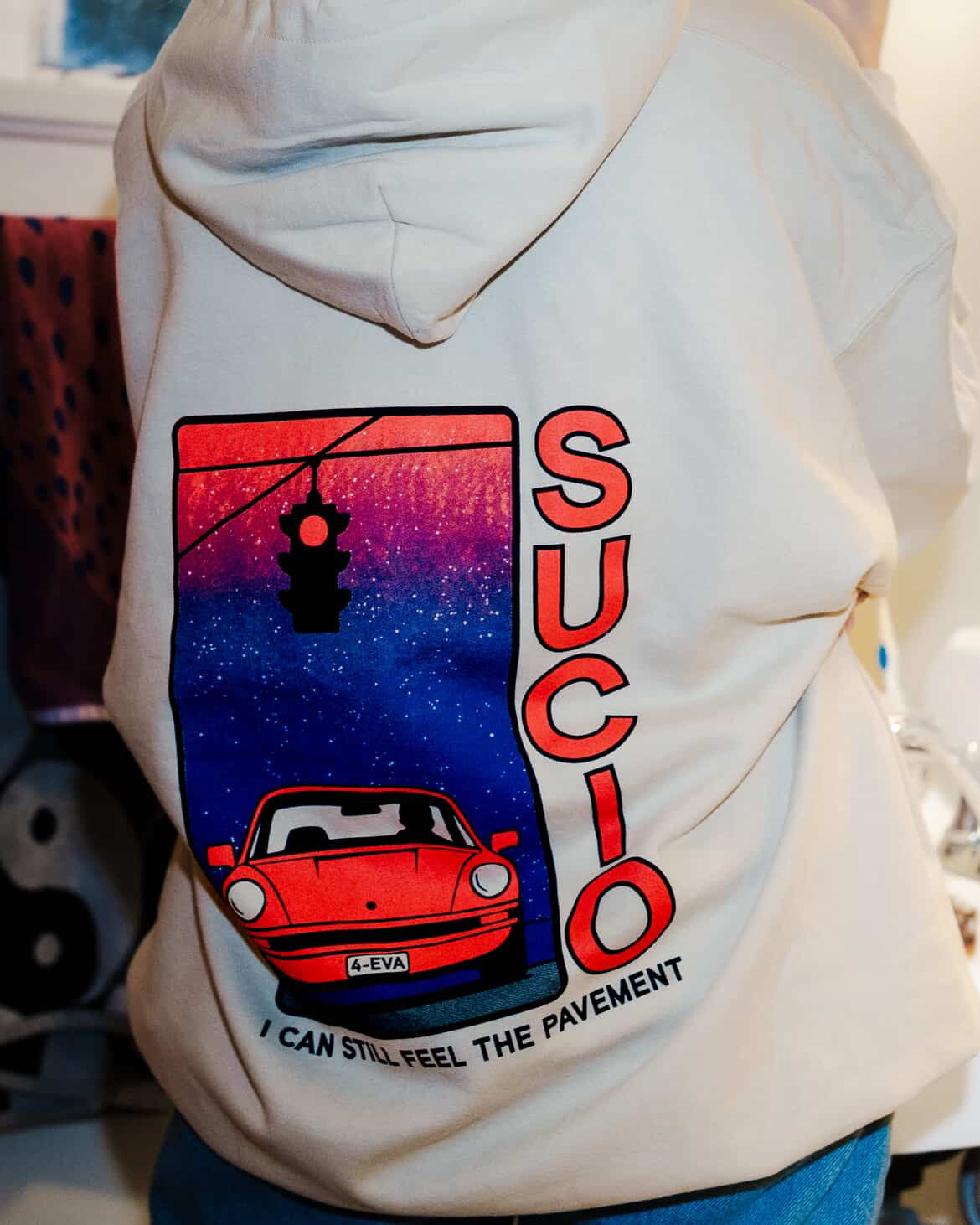 Off White sucio band hoodie with red and black text worn by a person