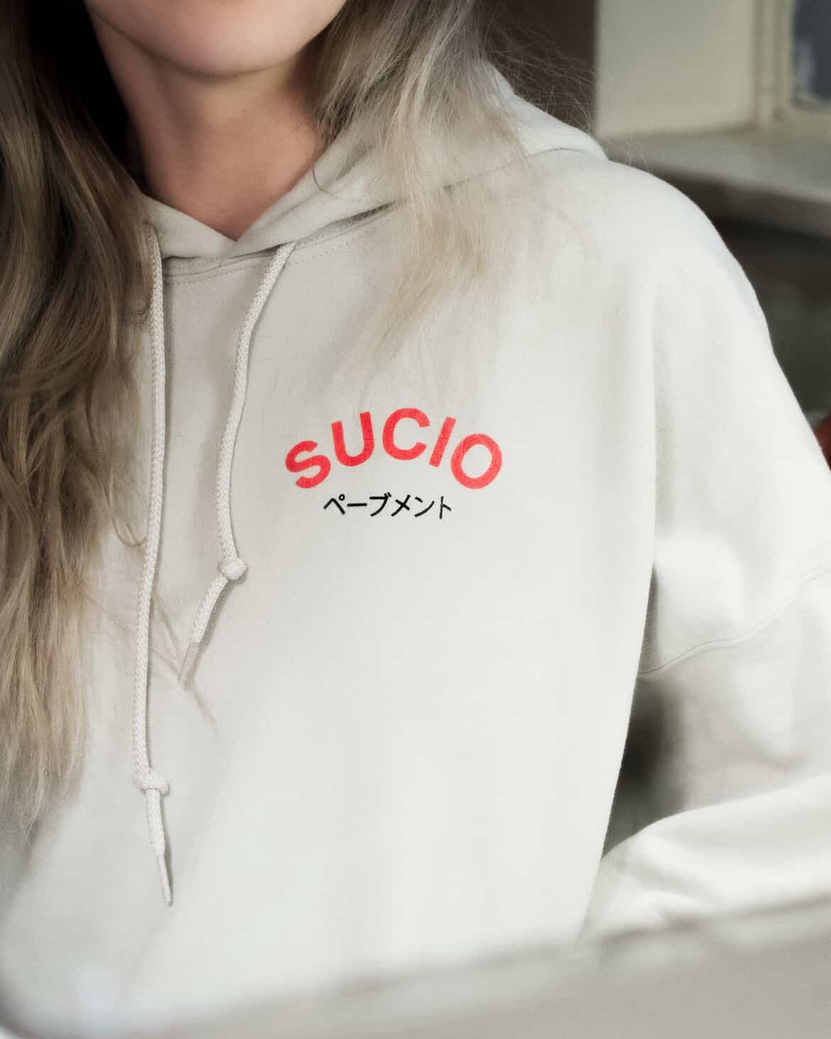 Off White sucio band hoodie with red and black text worn by a person