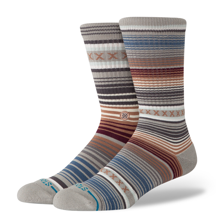 Two striped stance curren st crew socks with a pattern on a white background