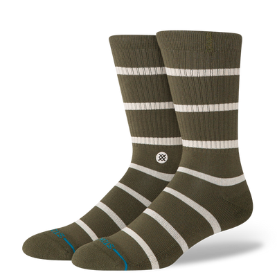 Pair of green stance butter blend crew socks with white stripes on a white background
