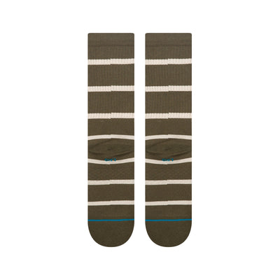 Pair of green stance butter blend crew socks with white stripes on a white background