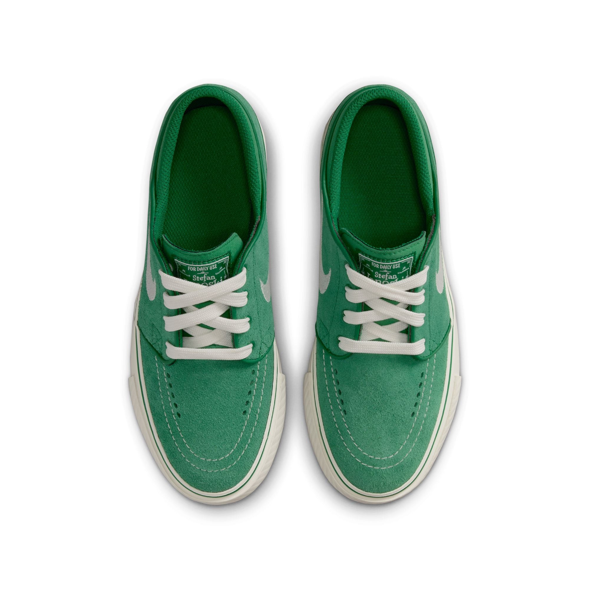Green big kids janoski sneaker with white Nike logo on a white background