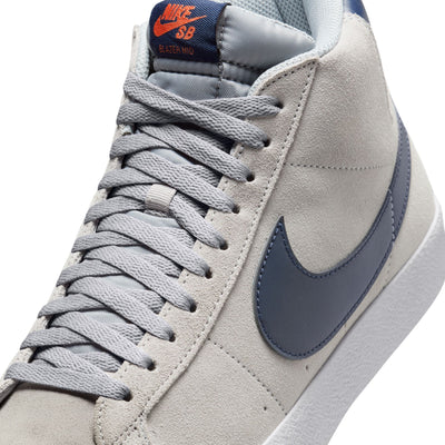 grey mid top nike sb blazer with blue nike swoosh and orange detail and white sole