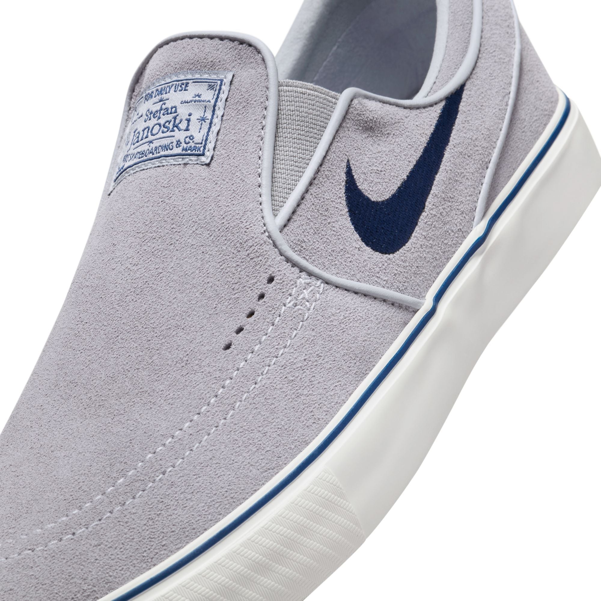 grey men's nike sb janoski slip-on with navy swoosh and white sole