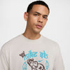 off white nike sb max90 skate tee shirt featuring an elephant and butterfly in brown with 2 tourches, a horseshoe and nike sb in light blue