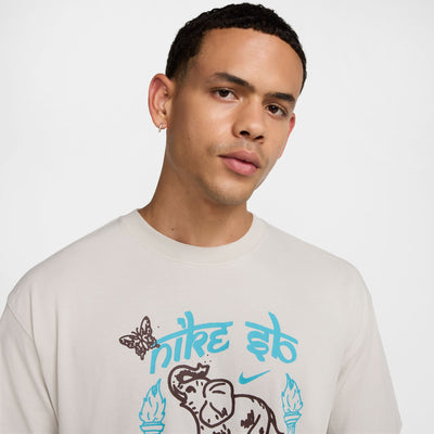 off white nike sb max90 skate tee shirt featuring an elephant and butterfly in brown with 2 tourches, a horseshoe and nike sb in light blue