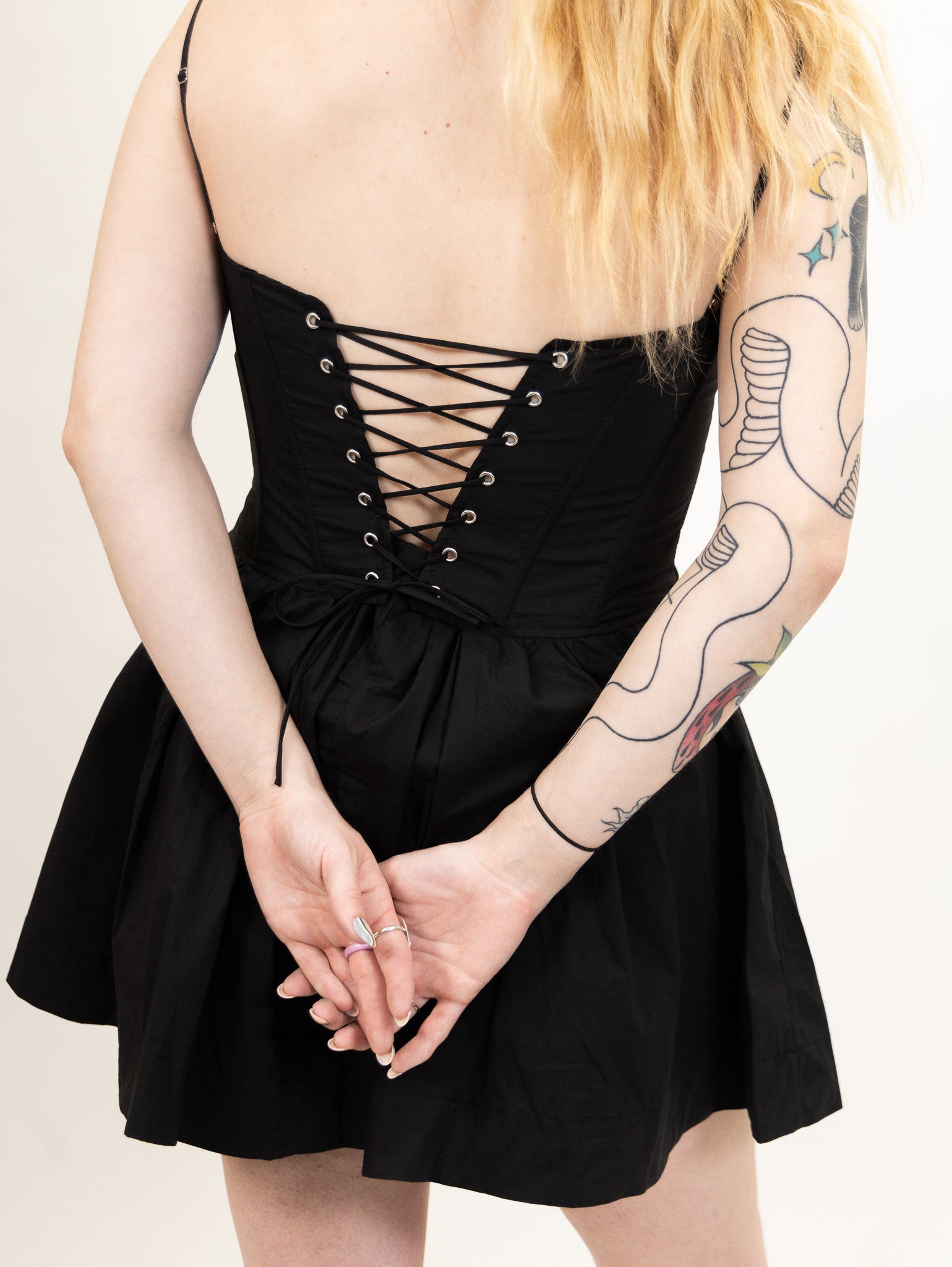 women's black Poplin fit and flare dress featuring a corset bodice and peek-a-boo lace bralette detail from nia