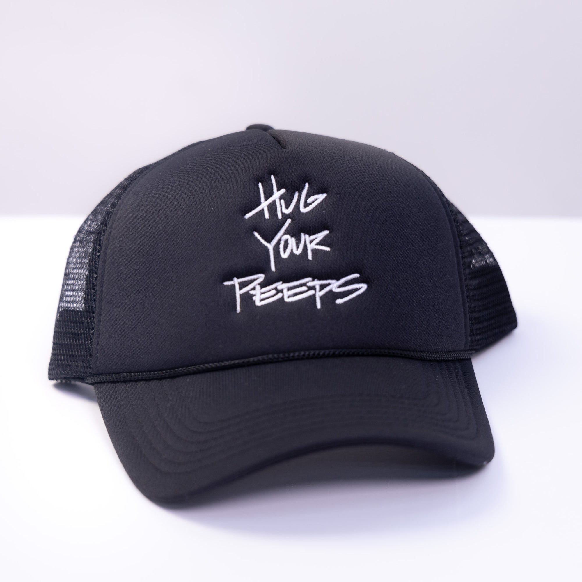 navy blue trucker hat with the slogan hug your peeps