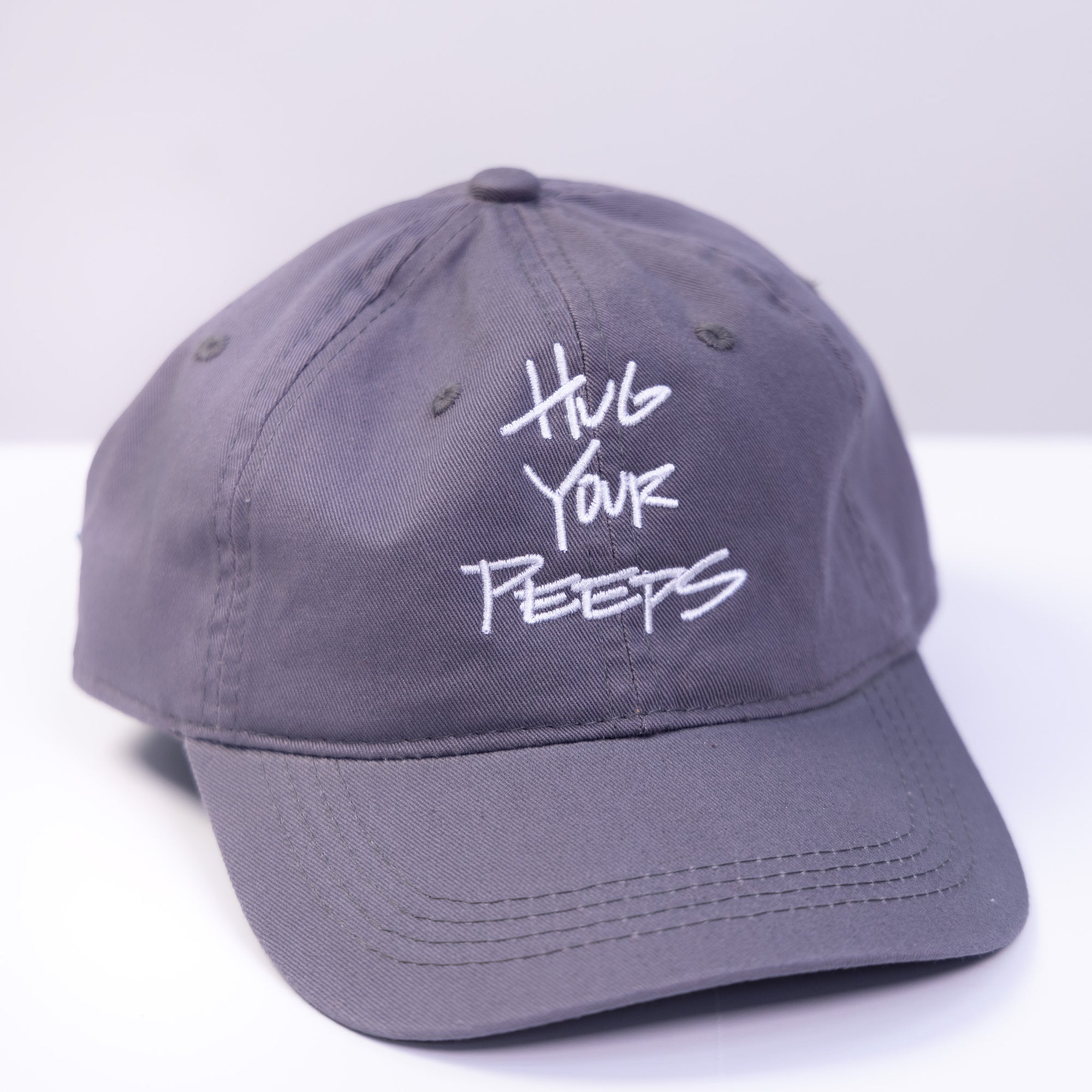 grey hat with the slogan hug your peeps