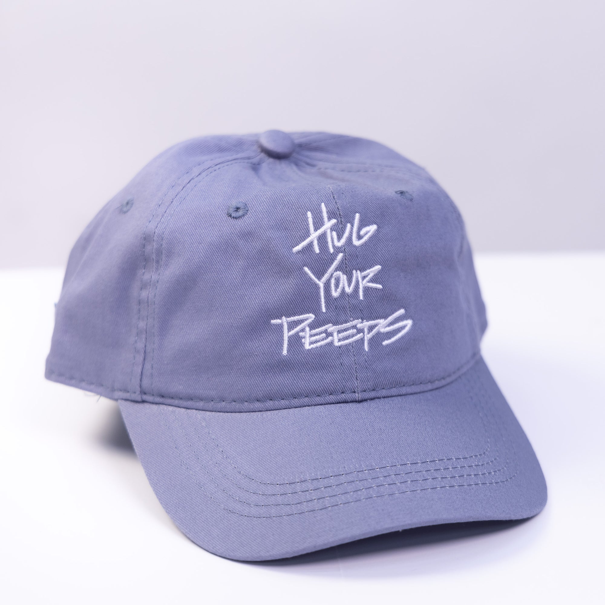 blue grey hat with the slogan hug your peeps