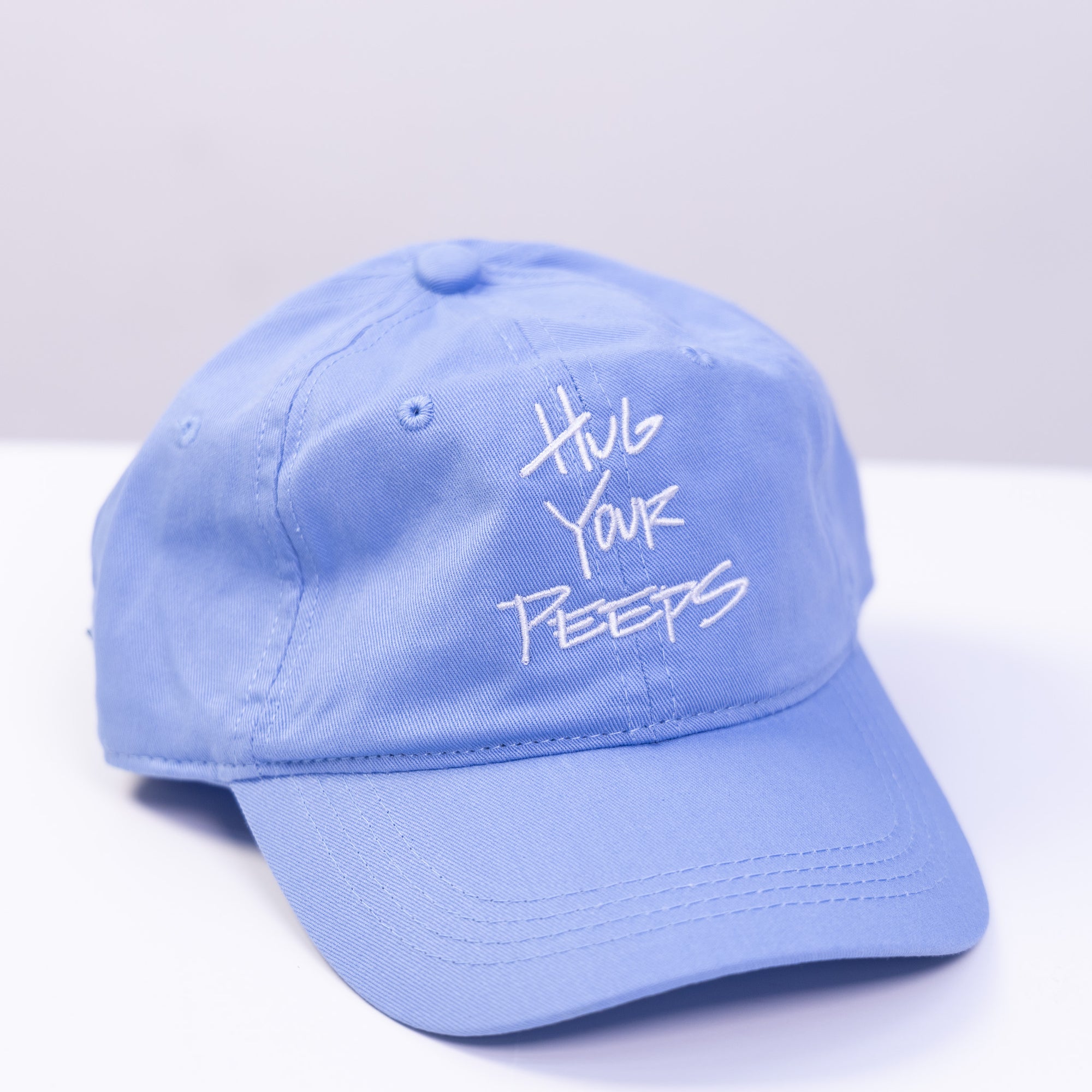 blue hat with the slogan hug your peeps