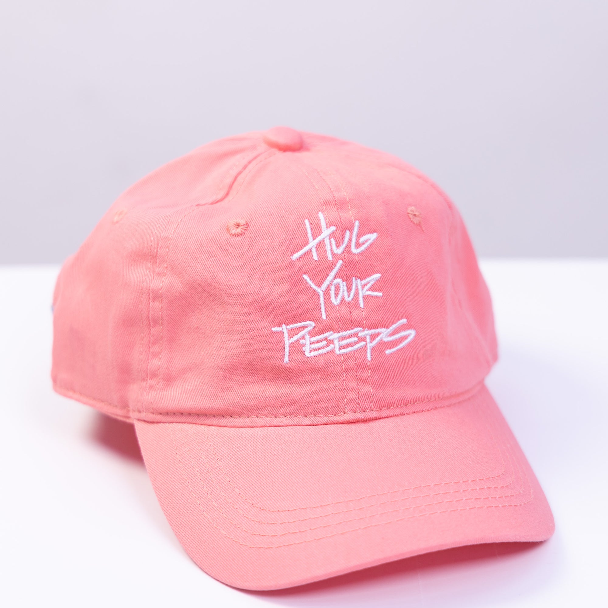 pink hat with the slogan hug your peeps