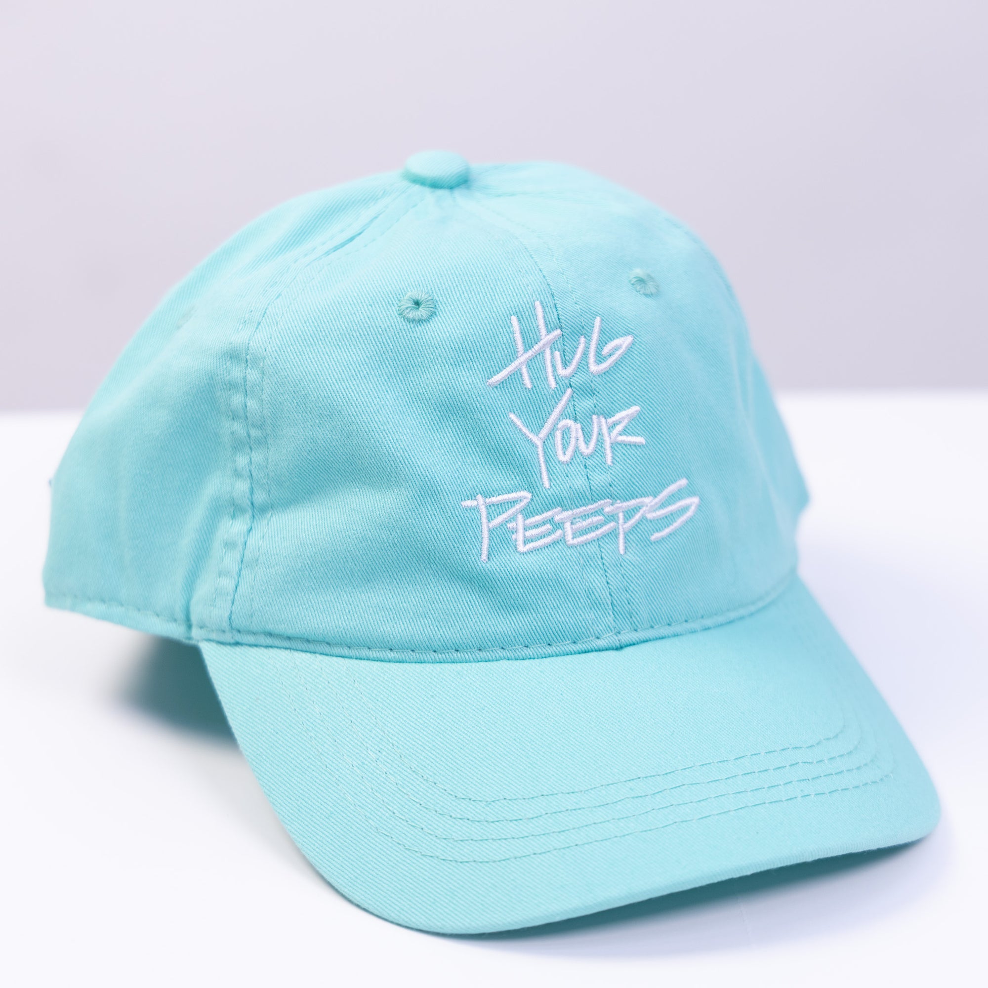 green hat with the slogan hug your peeps