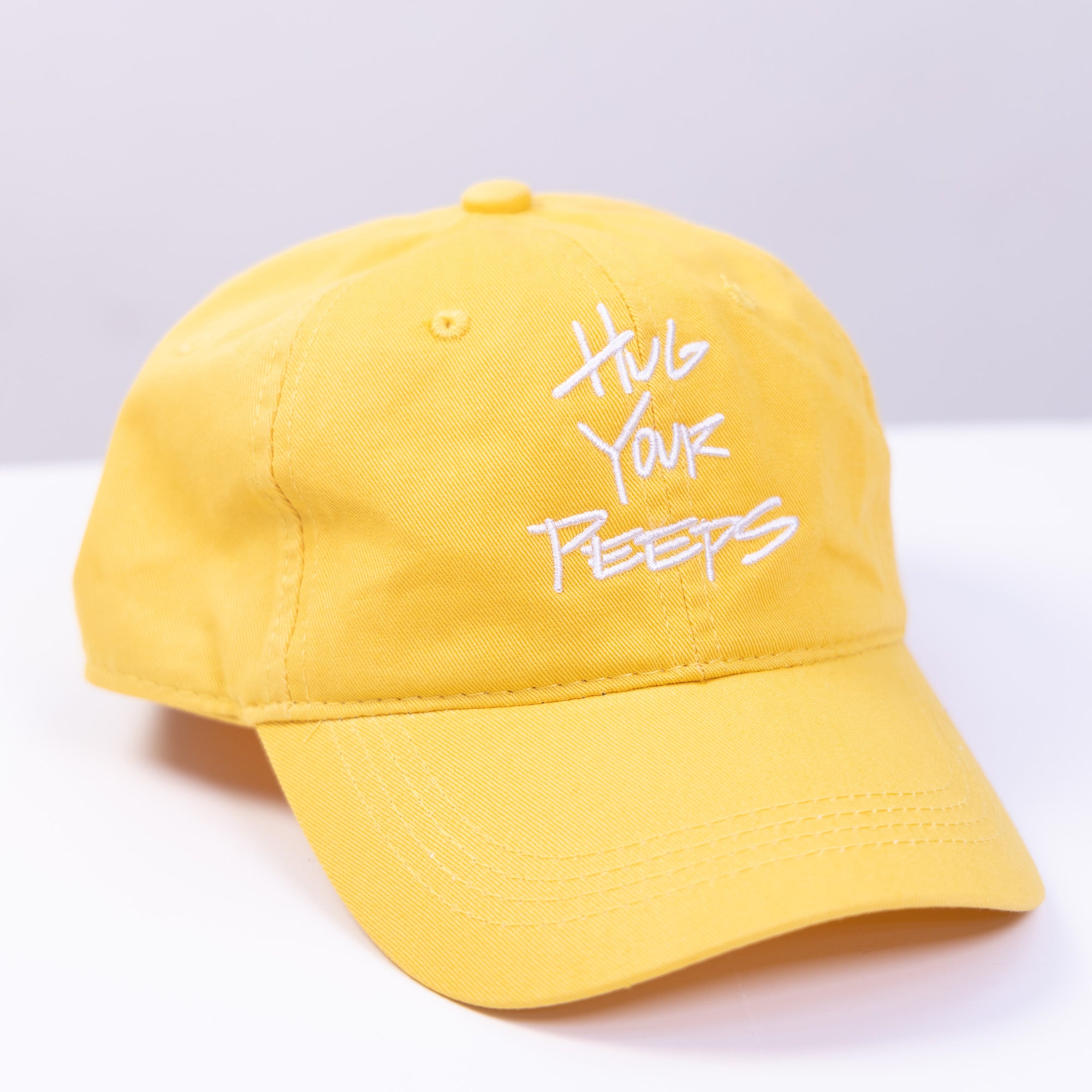 yellow hat with the slogan hug your peeps