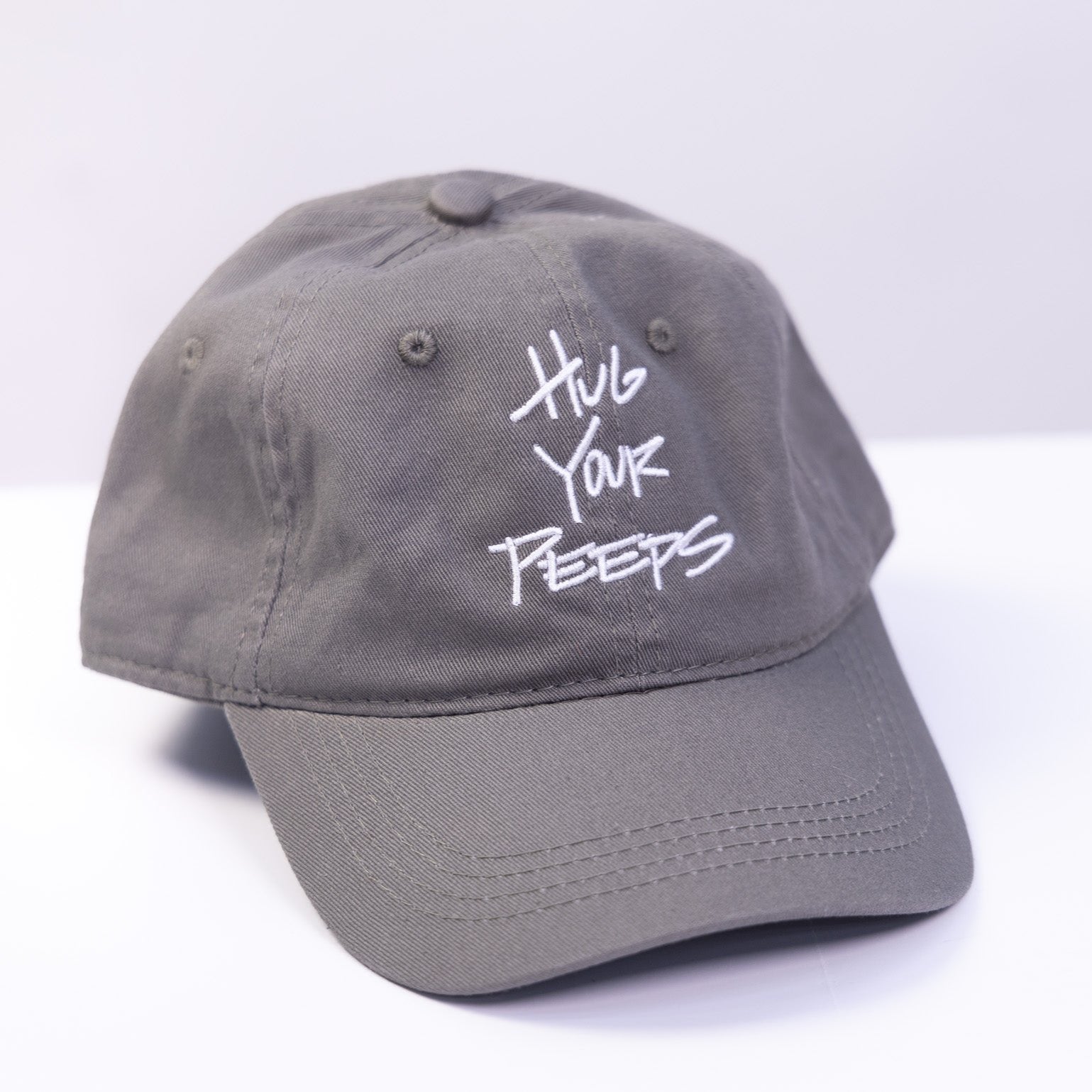 grey hat with the slogan hug your peeps