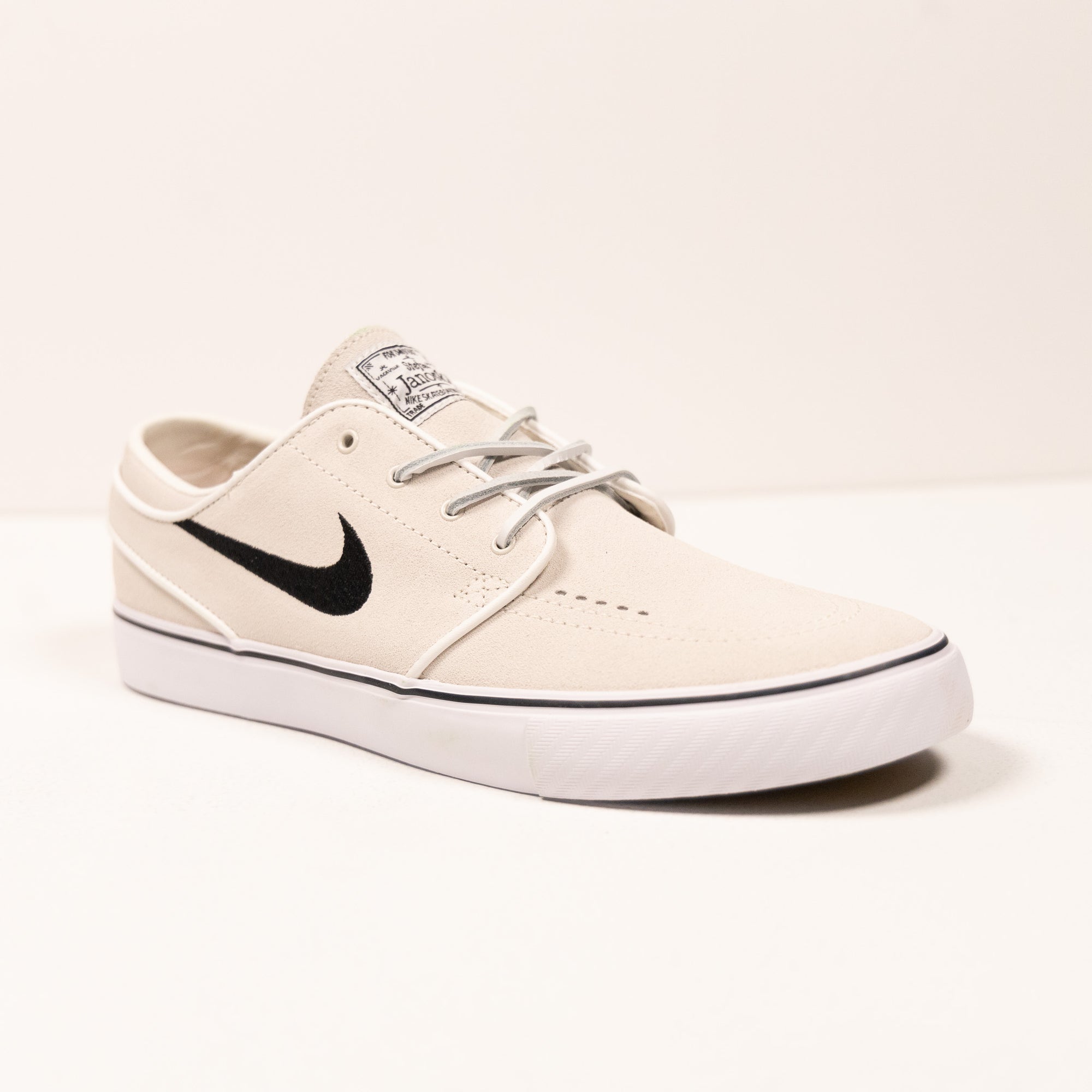 white nike sb stefan janoski men's skate shoe with black swoosh and white sole