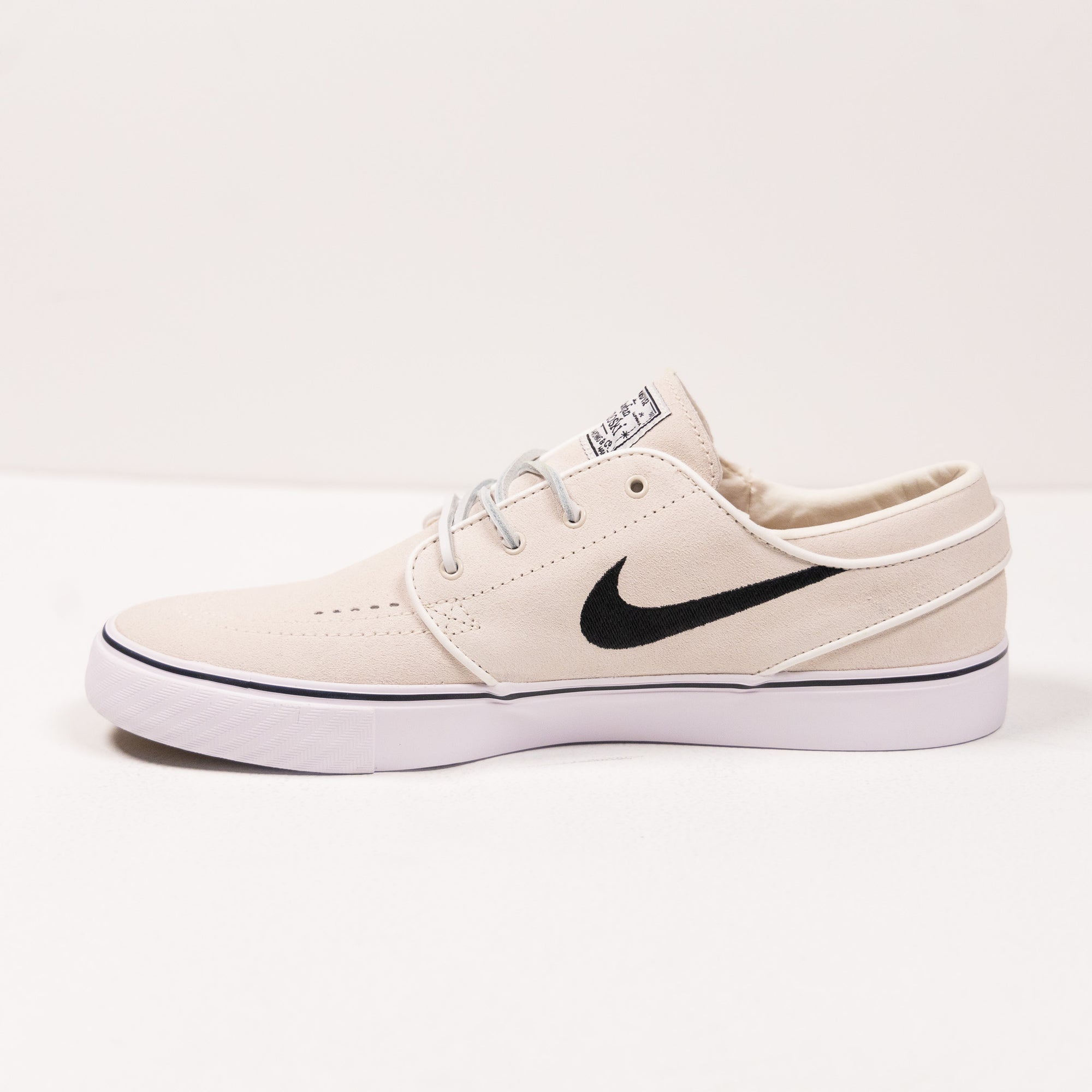 white nike sb stefan janoski men's skate shoe with black swoosh and white sole