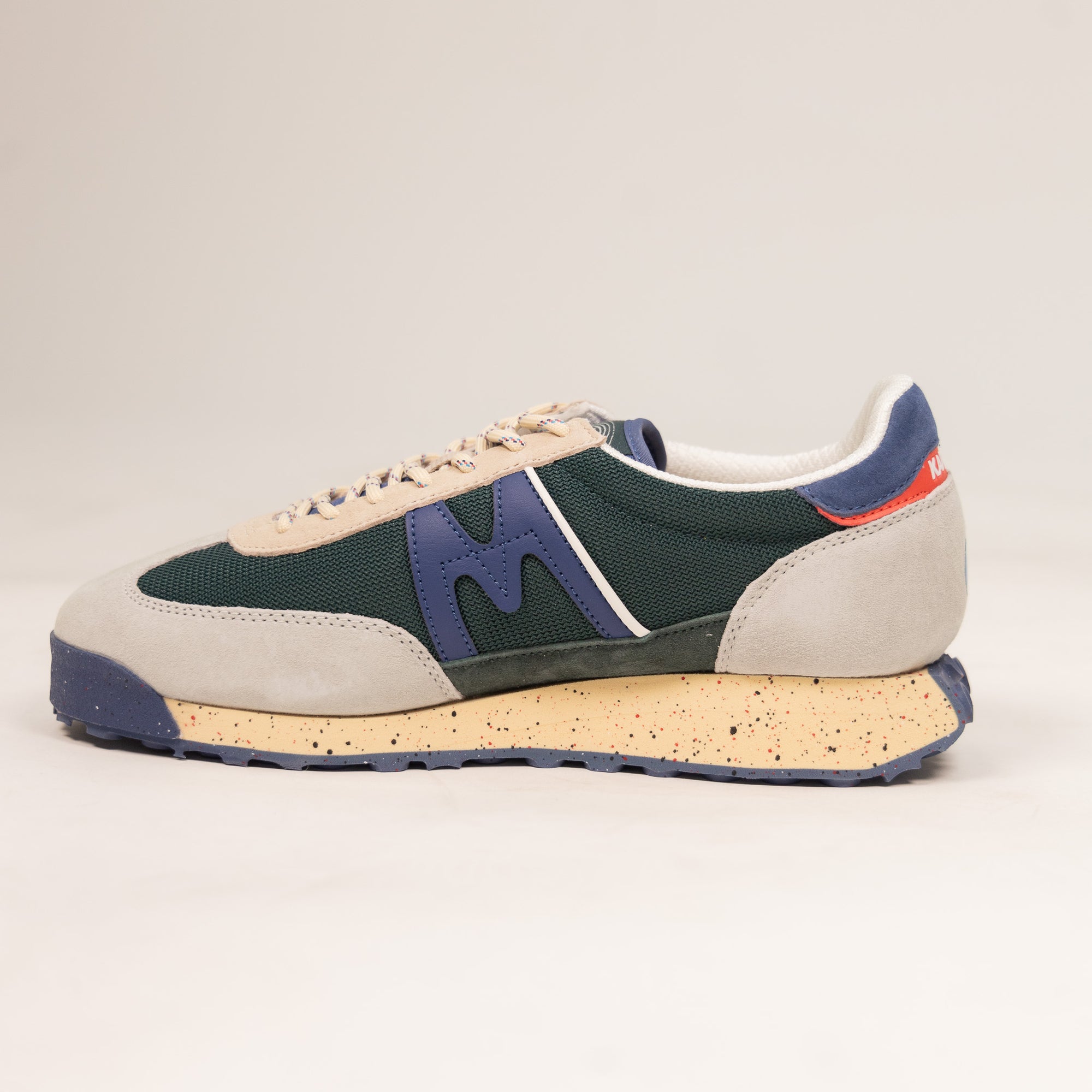 grey and green karhu men's shoe with speckled off white sole and blue details