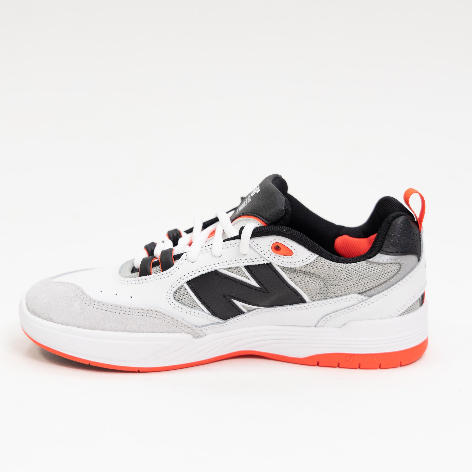 white and black new balance men's skate shoe with bright red detail