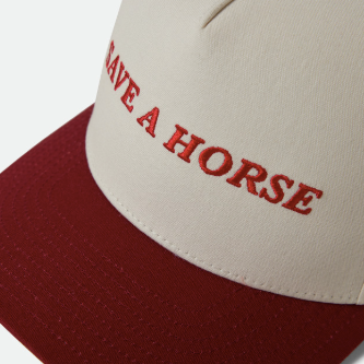 brixton hat with a red bill, off white top and the phrase save a horse on the front in red