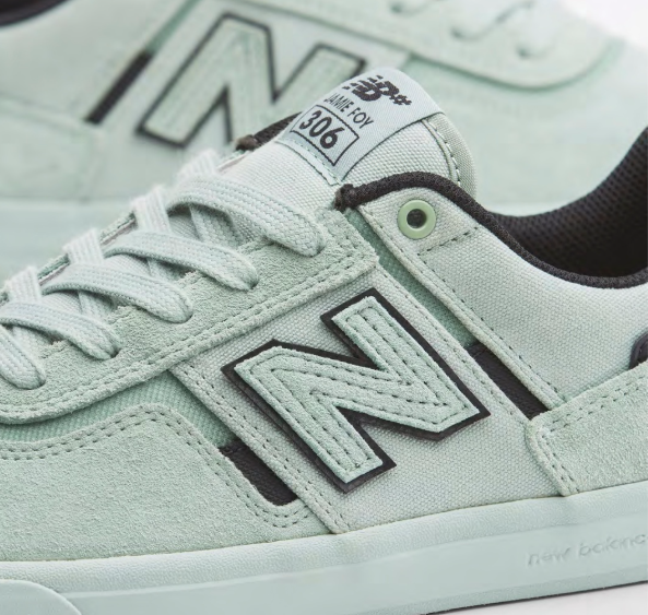 Light green new balance numeric jamie foy 306 signature sneaker with black accents on a white background