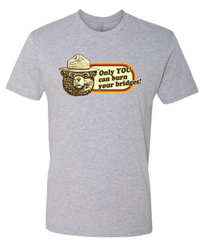 Gray t-shirt with a graphic design featuring a smokey the bear and text that reads only you can burn your bridges on a white background