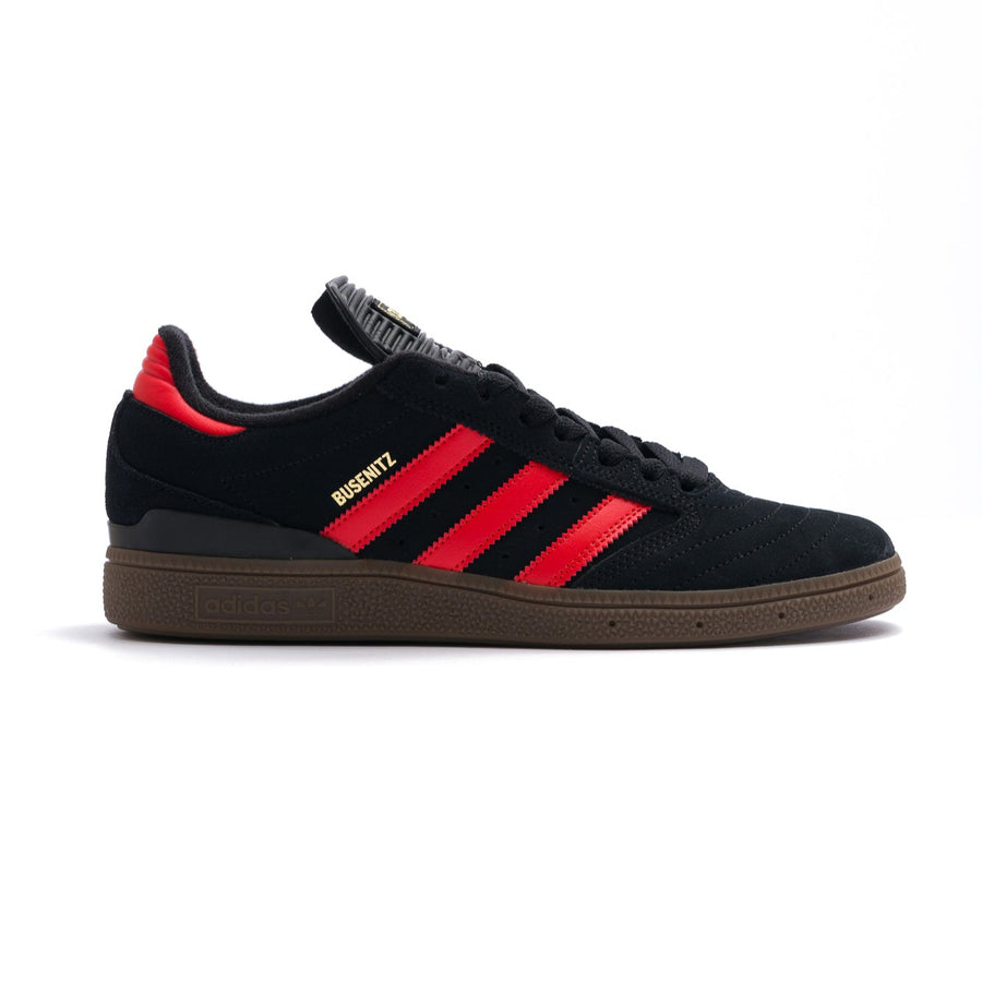 black adidas busentiz men's skate shoes with three orange stripes and a gum sole